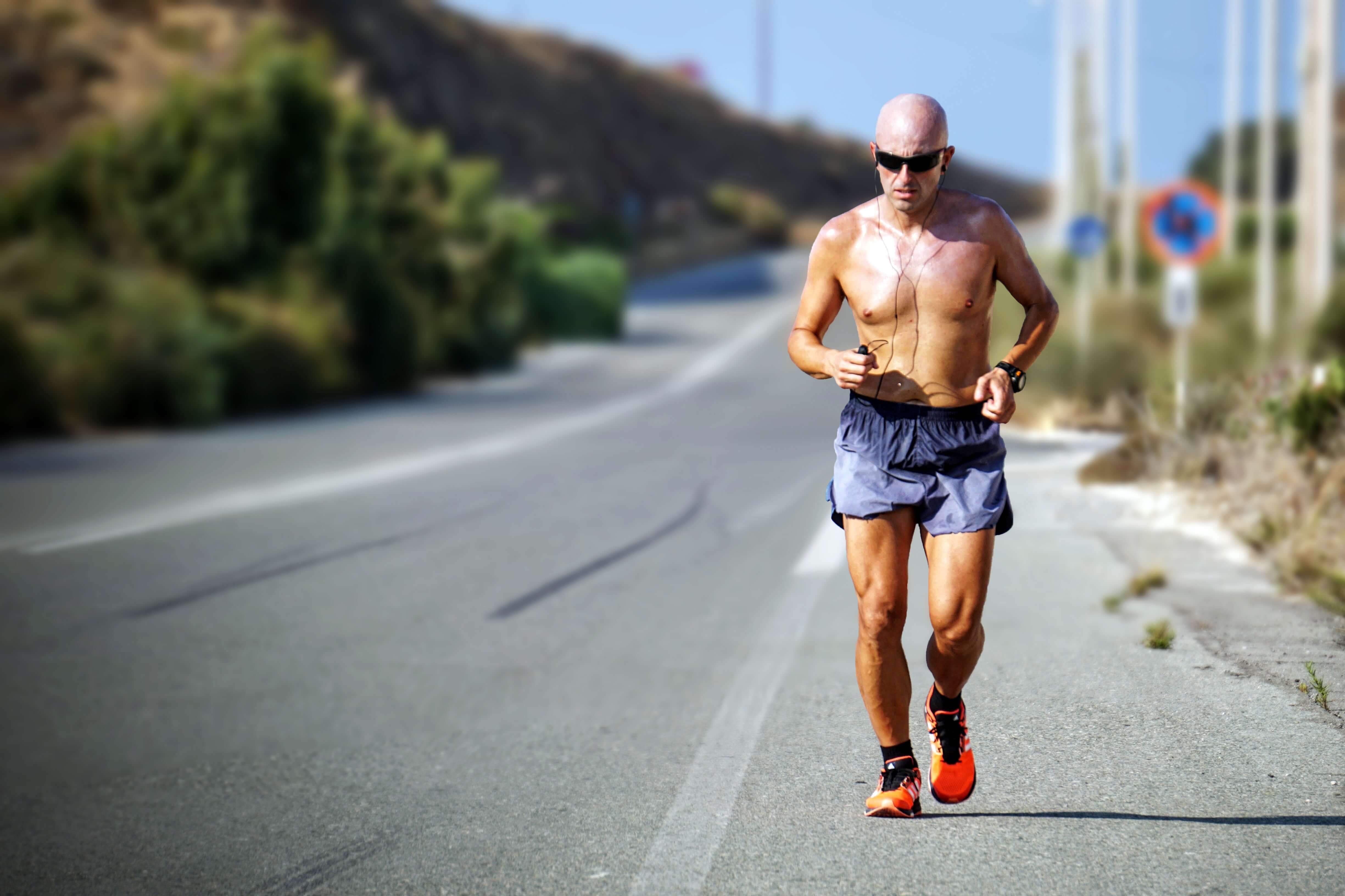 Man running on a rural road in summer